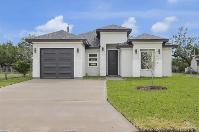 a front view of a house with a yard and garage