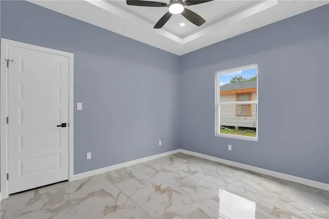 an empty room with a window and a ceiling fan