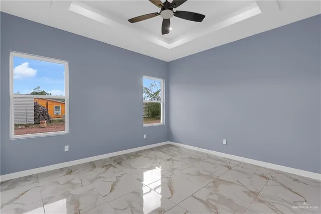 an empty room with windows and fan