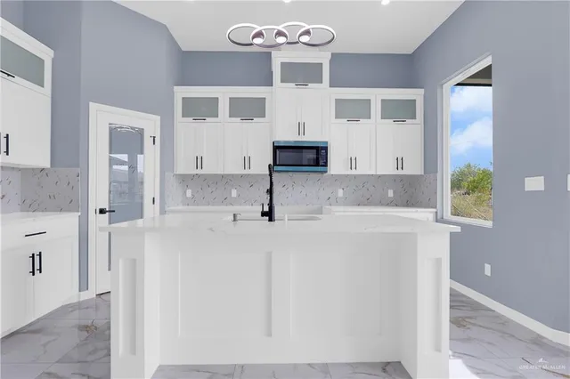 a kitchen with stainless steel appliances granite countertop a sink and a refrigerator