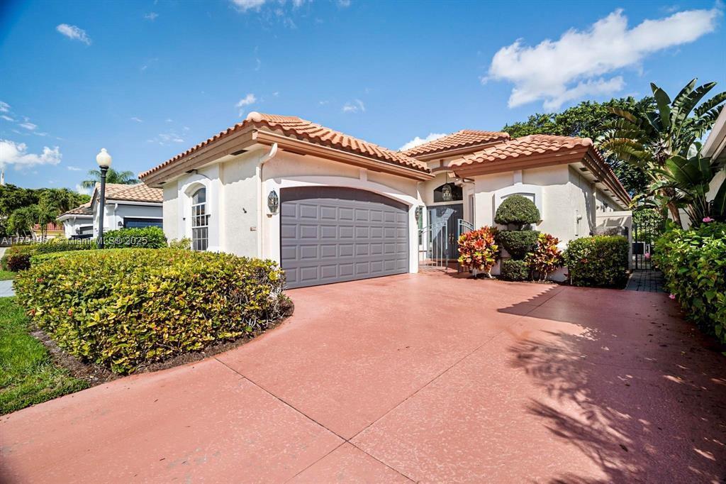 6375 Northwest 24th Street Boca Raton, FL 33434 - Photo 1 of 13 a front view of a house with a yard and garage