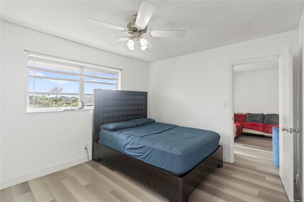 5800 Margate Boulevard, Unit 3463 Margate, FL 33063 - Photo 11 of 37 a bedroom with a bed and a chandelier