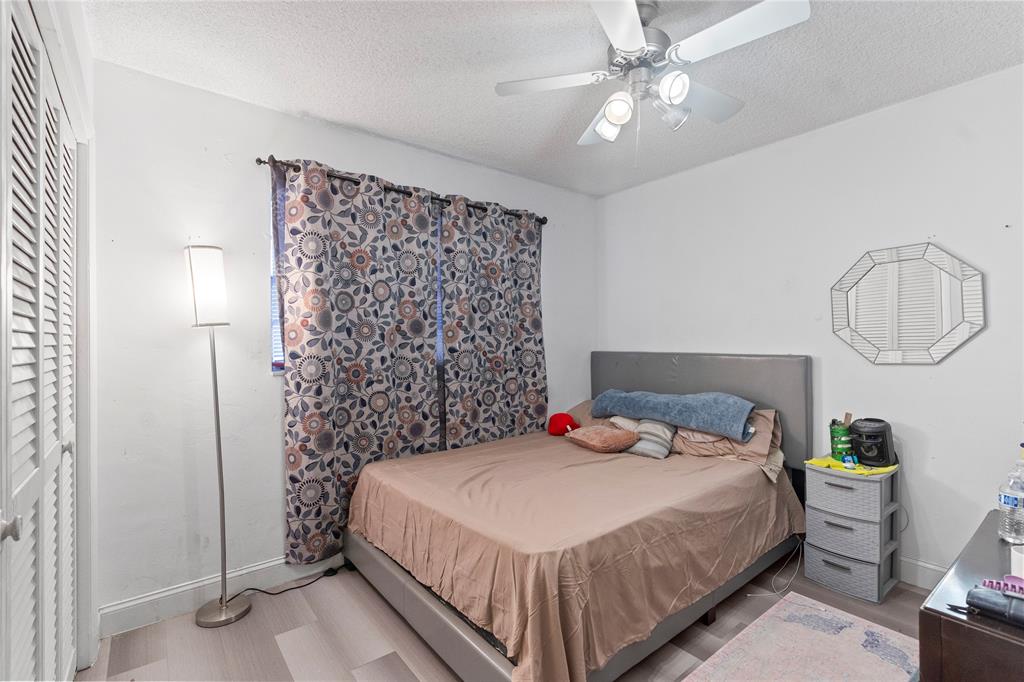 5800 Margate Boulevard, Unit 3463 Margate, FL 33063 - Photo 17 of 37 a bedroom with a bed a chandelier and a mirror