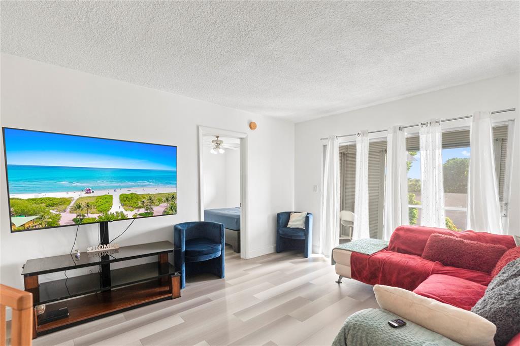5800 Margate Boulevard, Unit 3463 Margate, FL 33063 - Photo 3 of 37 a living room with furniture floor to ceiling window and wooden floor