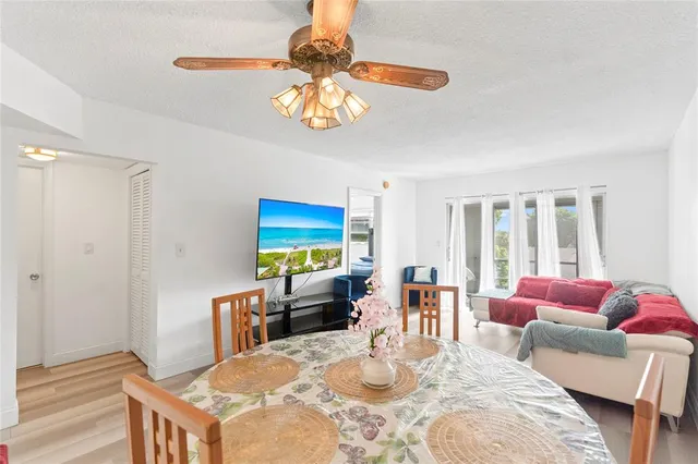 a dining room with furniture a chandelier and a flat screen tv