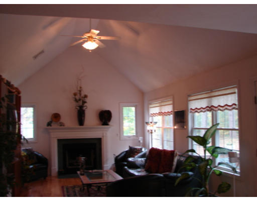 139 Gates Pond Road Berlin, MA 01503 - Photo 3 of 12 a living room with furniture a chandelier and a fireplace