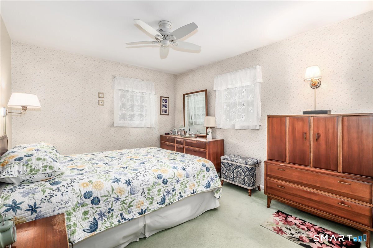 75 Centerbrook Road Fairfield, CT 06824 - Photo 22 of 39 Primary bedroom, hardwood floor under carpet, ceiling fan.