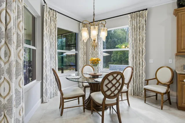 a dining room with furniture a chandelier and wooden floor