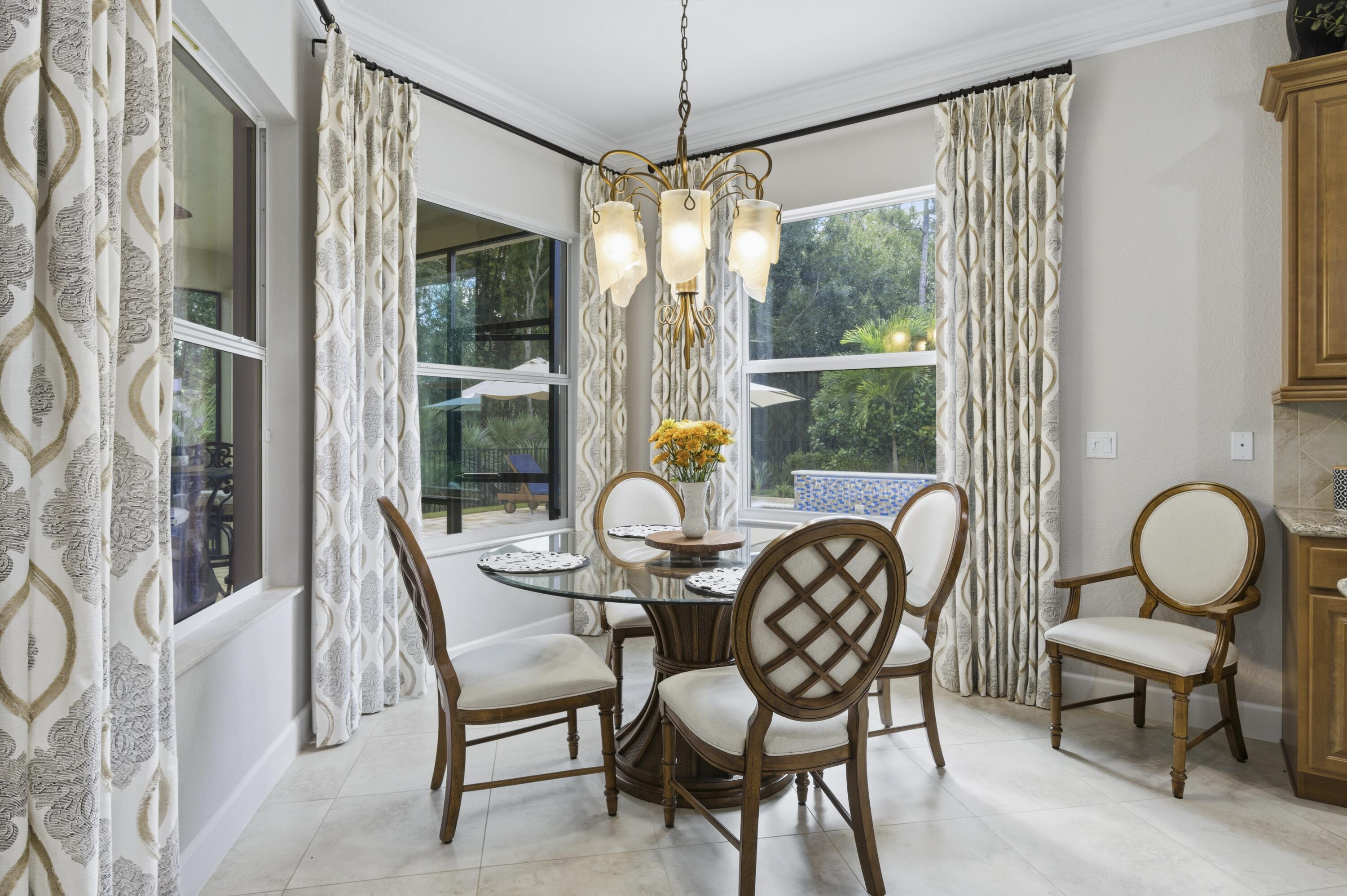 1016 Southwest Triste Way Stuart, FL 34997 - Photo 11 of 41 a dining room with furniture a chandelier and wooden floor