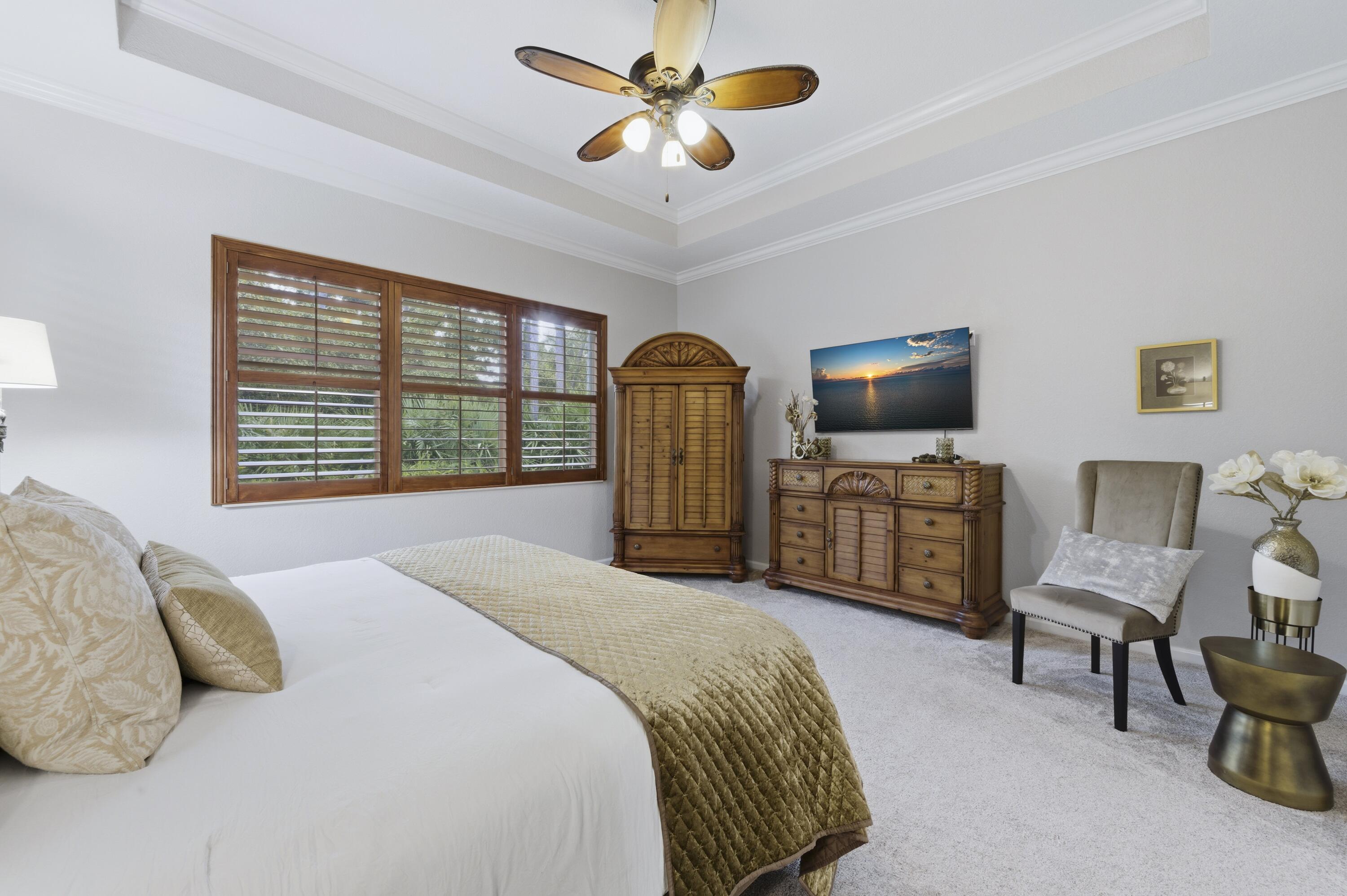 1016 Southwest Triste Way Stuart, FL 34997 - Photo 16 of 41 a bedroom with a bed furniture and a flat screen tv