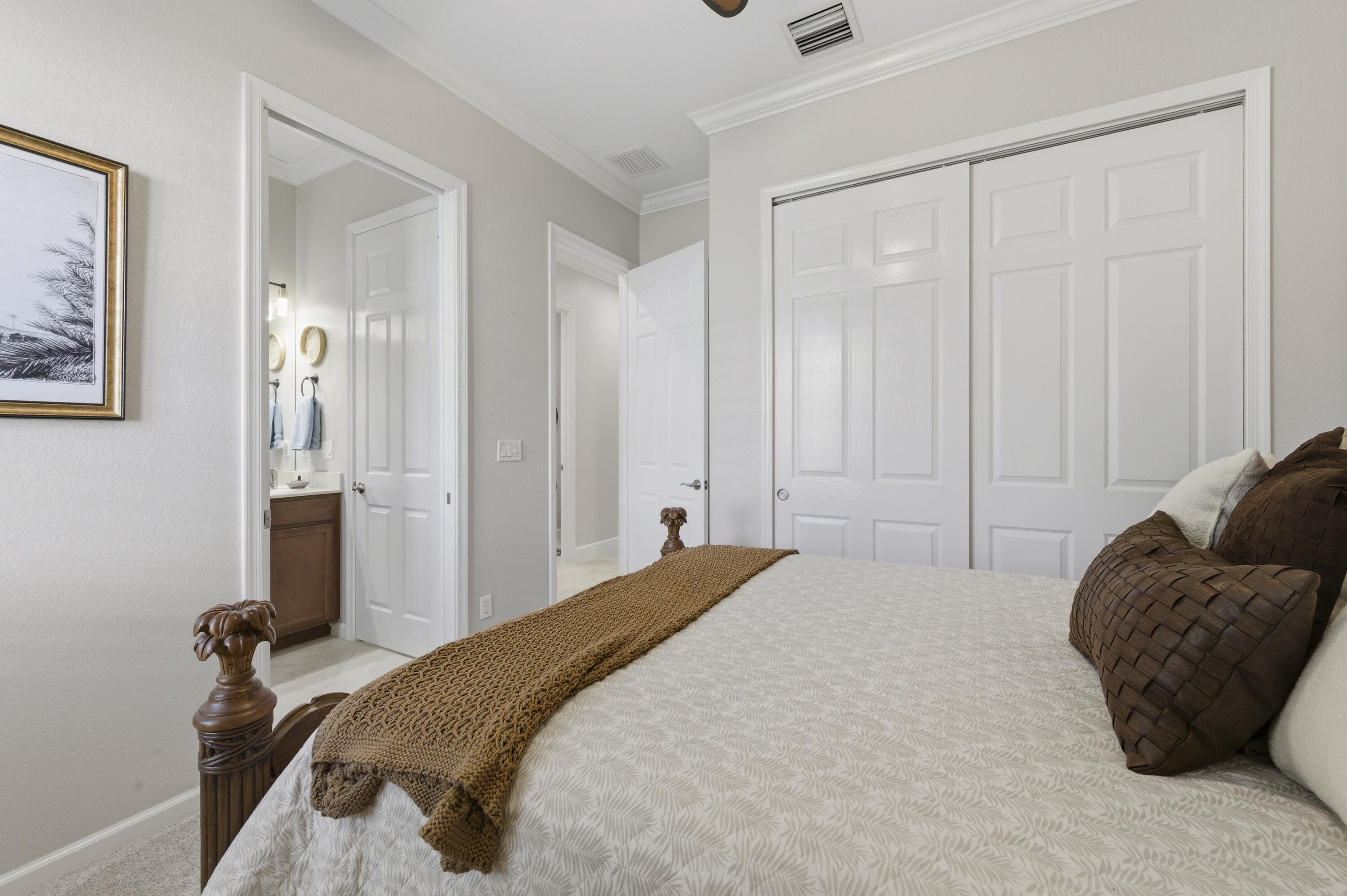 1016 Southwest Triste Way Stuart, FL 34997 - Photo 21 of 41 a bedroom with a bed and a painting on the wall