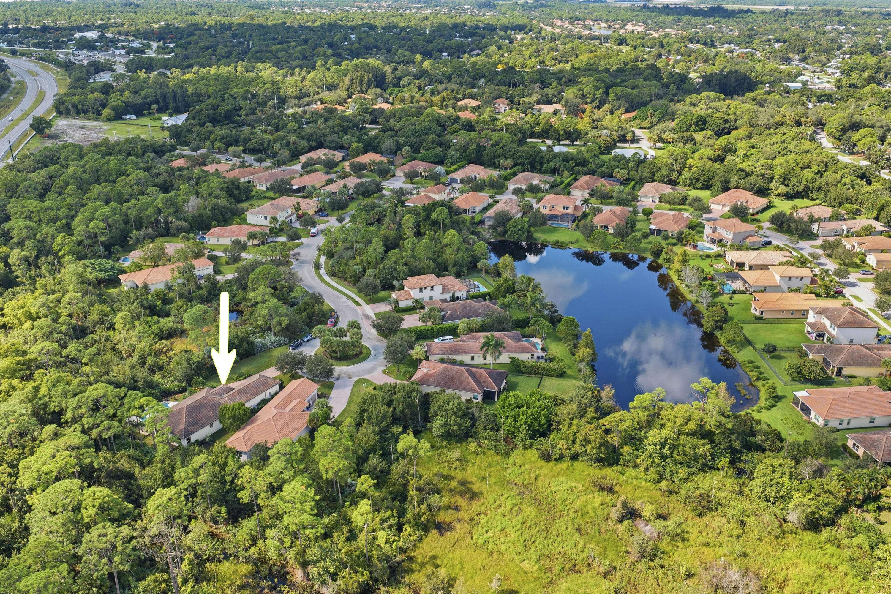 1016 Southwest Triste Way Stuart, FL 34997 - Photo 38 of 41 an aerial view of residential house with outdoor space and trees all around