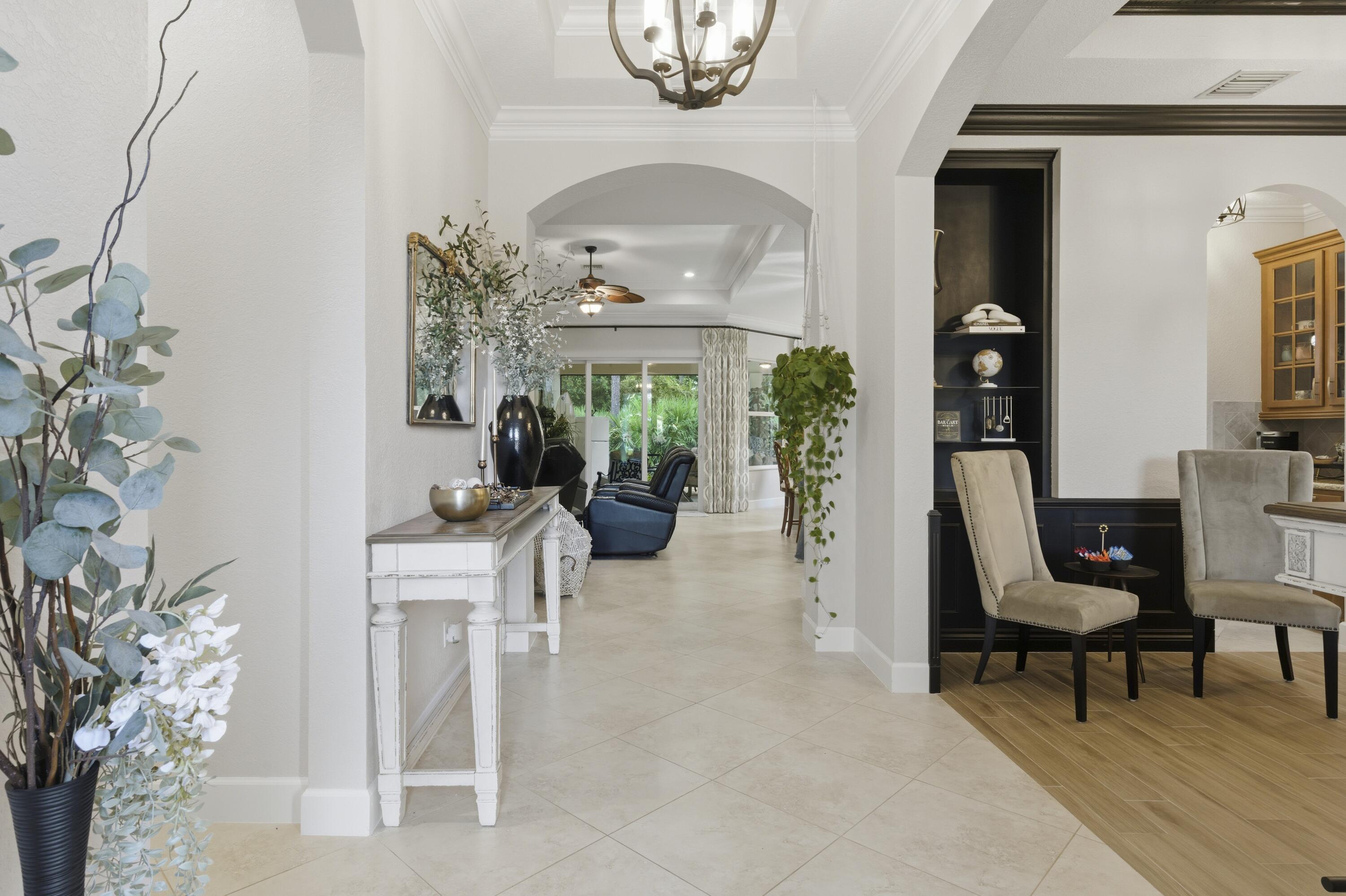 1016 Southwest Triste Way Stuart, FL 34997 - Photo 4 of 41 a living room with furniture a potted plant and a chandelier