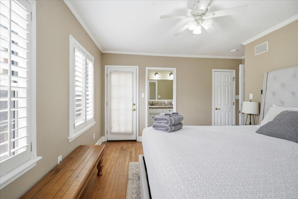 2702 20th Street Lubbock, TX 79410 - Photo 19 of 34 a spacious bedroom with a bed and a chandelier