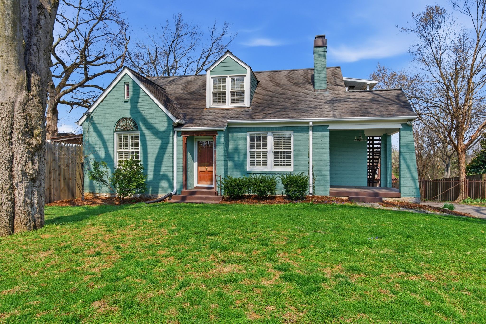 a front view of a house with a yard and trees