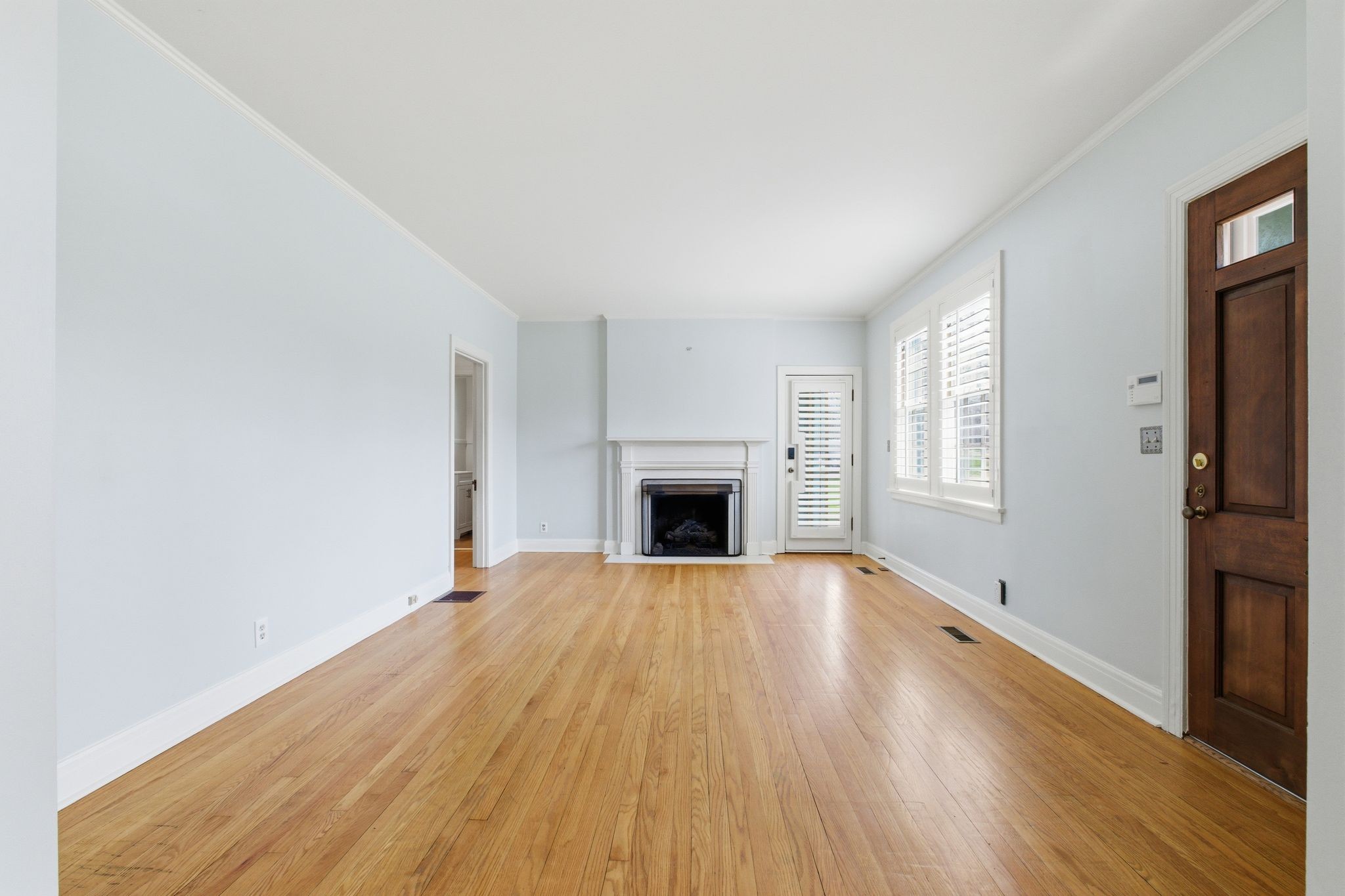 1002 Sutton Hill Road Nashville, TN 37204 - Photo 3 of 34 an empty room with wooden floor and a fireplace