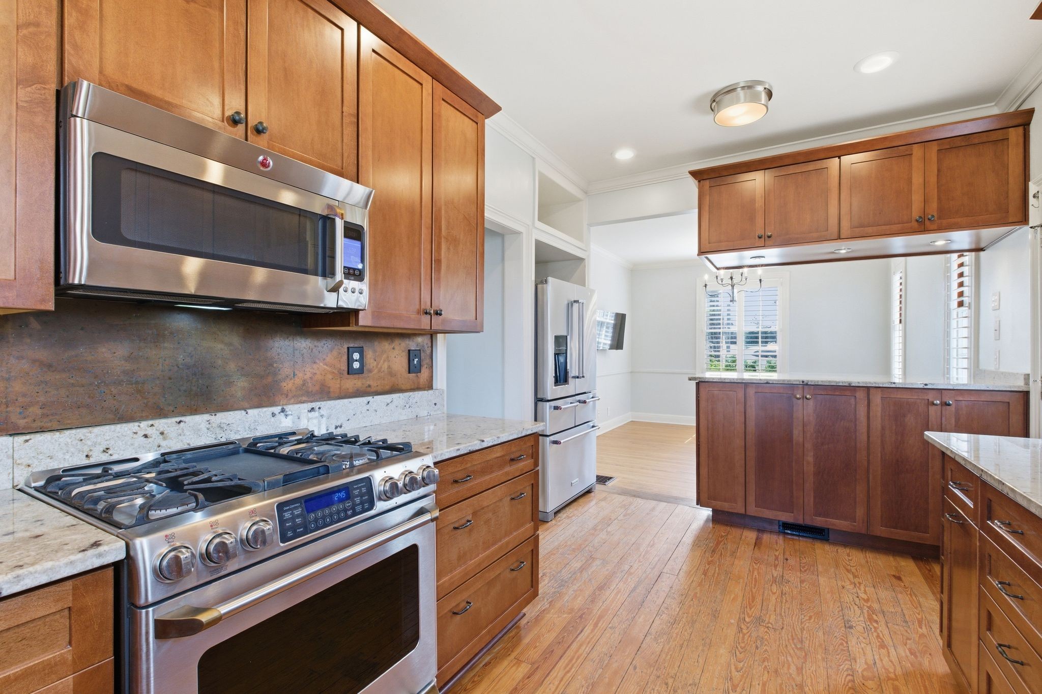 1002 Sutton Hill Road Nashville, TN 37204 - Photo 10 of 34 a kitchen with stainless steel appliances a stove a microwave and wooden cabinets