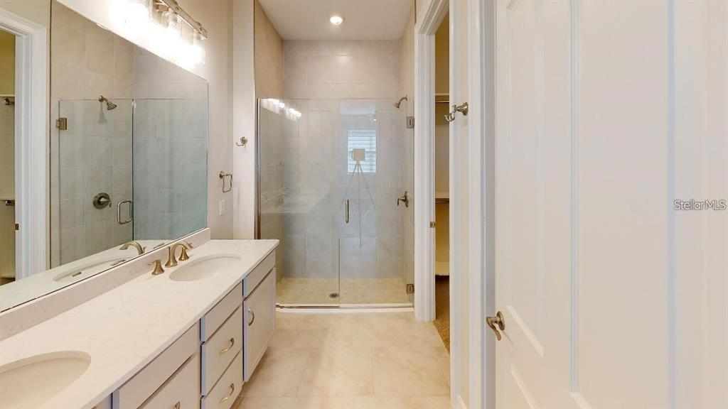 127 Ibiza Loop Venice, FL 34292 - Photo 9 of 20 a bathroom with a bathtub shower sink vanity and a mirror