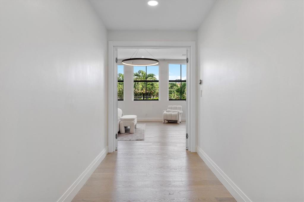 9 Tahoe Lane Sea Ranch Lakes, FL 33308 - Photo 40 of 99 a view of a hallway with wooden floor and a living room