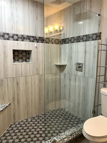 a kitchen with stainless steel appliances white cabinets and wooden floor