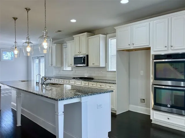 a kitchen with stainless steel appliances a stove a sink and a microwave