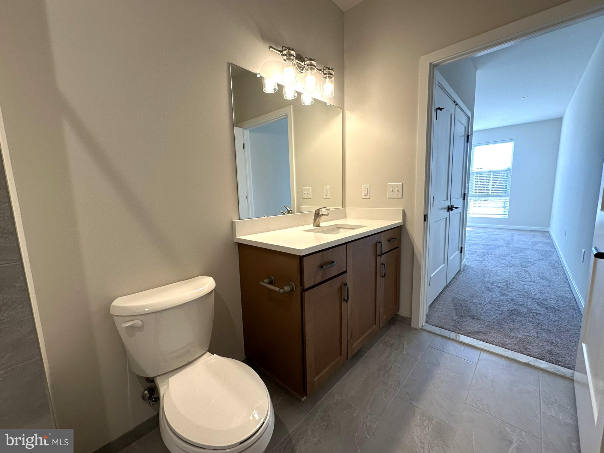 409 West Butler Avenue, Unit 223 Chalfont, PA 18914 - Photo 18 of 33 a bathroom with a toilet sink vanity and mirror