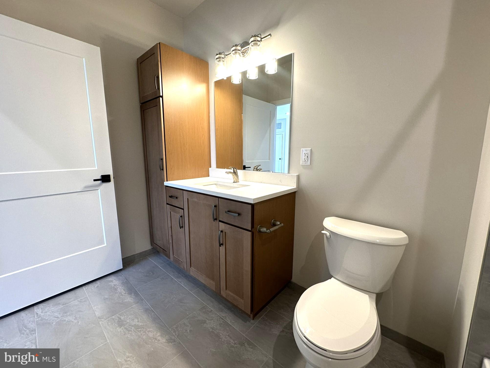 409 West Butler Avenue, Unit 223 Chalfont, PA 18914 - Photo 23 of 33 a bathroom with a toilet sink vanity and mirror