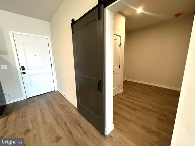 an empty room with wooden floor and entrance