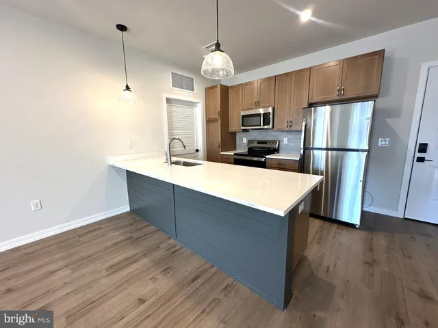 a kitchen with wooden cabinets and stainless steel appliances
