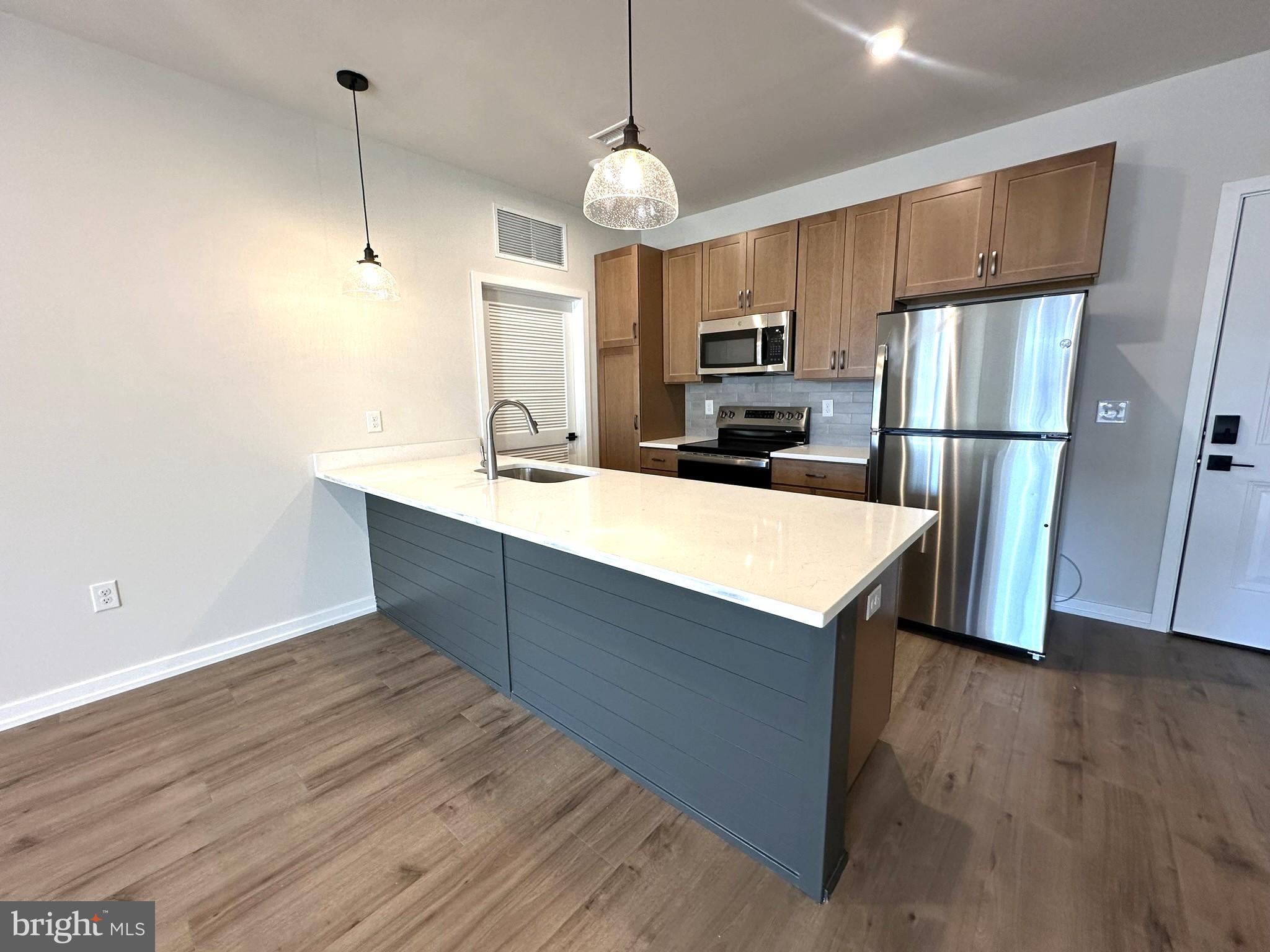 409 West Butler Avenue, Unit 223 Chalfont, PA 18914 - Photo 5 of 33 a kitchen with wooden cabinets and stainless steel appliances