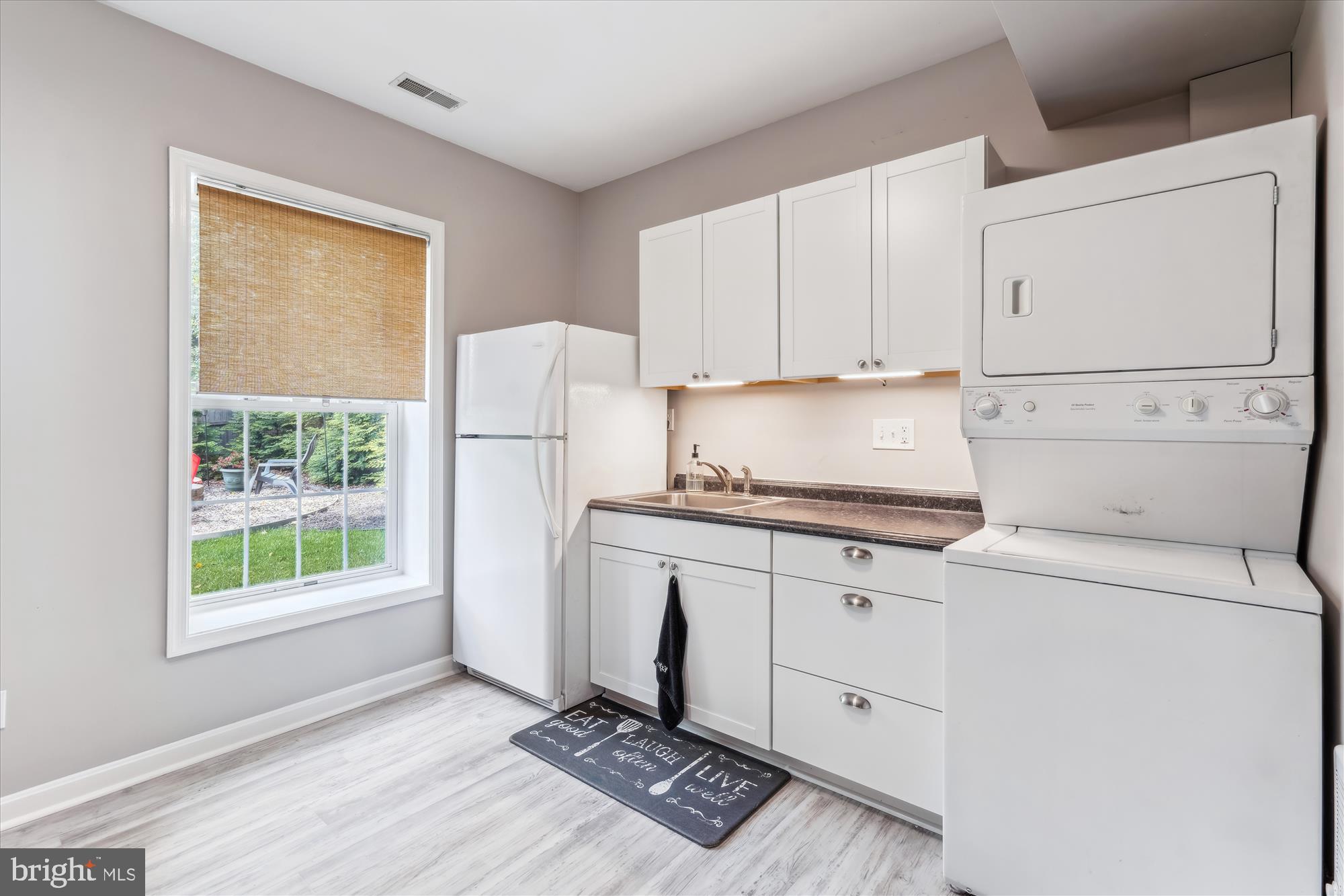 1043 Skyview Drive Annapolis, MD 21409 - Photo 60 of 71 a kitchen with granite countertop a sink a stove a refrigerator a window and white cabinets