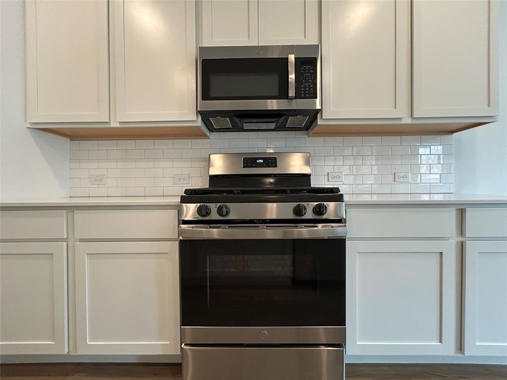213 Post Oak Street Azle, TX 76020 - Photo 13 of 24 a kitchen with stainless steel appliances granite countertop a stove and a microwave