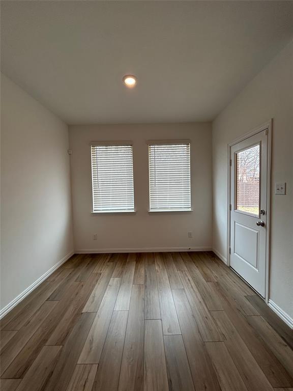 213 Post Oak Street Azle, TX 76020 - Photo 16 of 24 an empty room with wooden floor and windows