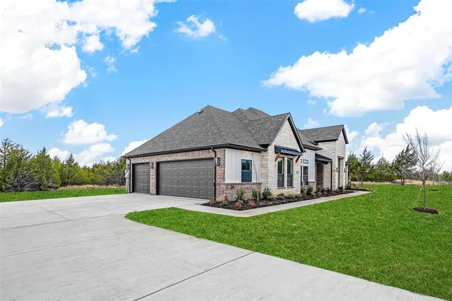 a front view of a house with a garden and yard