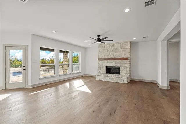 an empty room with windows and fireplace