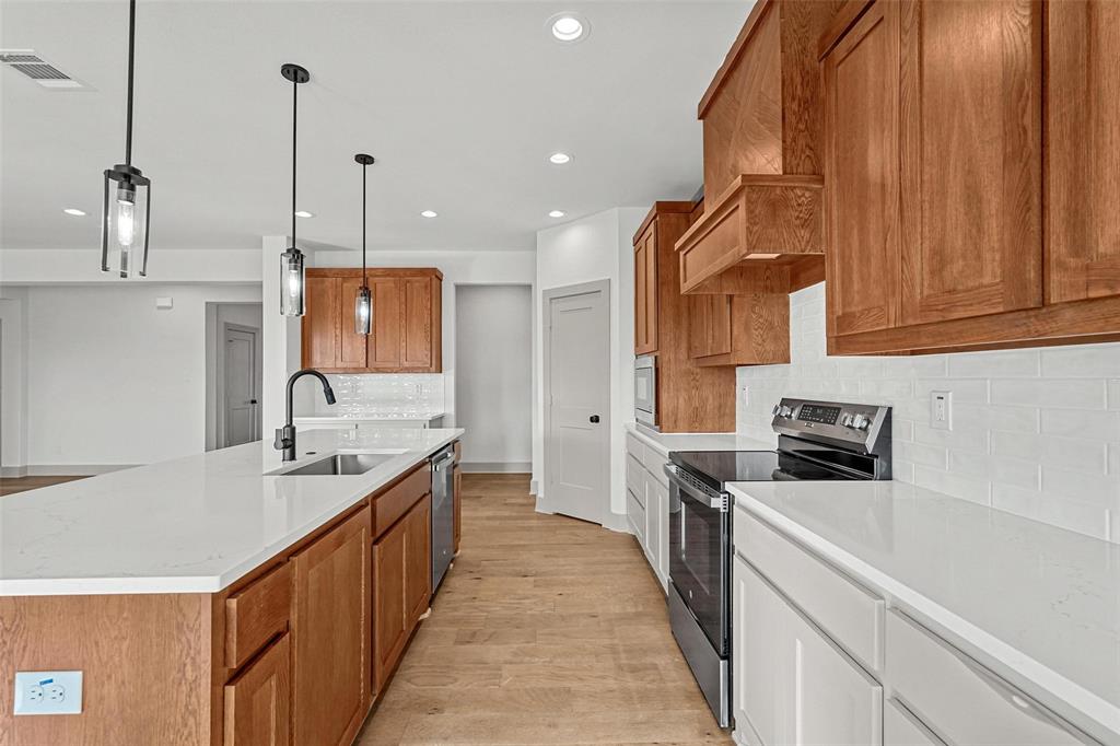 730 Evergreen Nevada, TX 75173 - Photo 10 of 40 a kitchen with stainless steel appliances granite countertop a sink a stove and a wooden floors