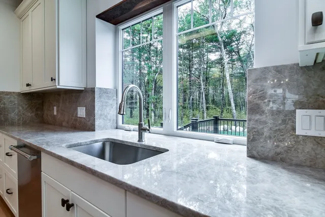 a large kitchen with granite countertop a sink and dishwasher a stove with wooden floor