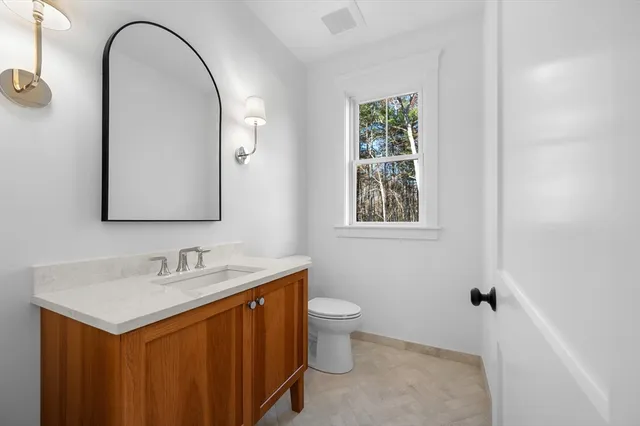 a bathroom with a sink a toilet and a mirror