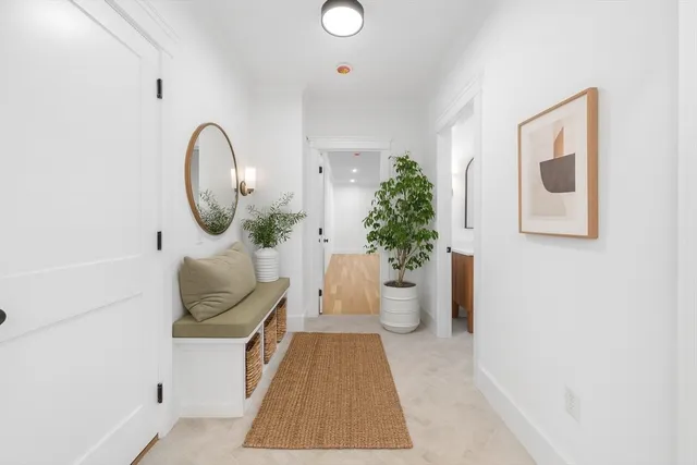 a view of a hallway with wooden floor and staircase