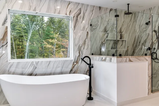 a bathroom with a tub sink and mirror