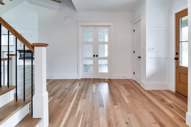 a view of empty room with wooden floor and fan