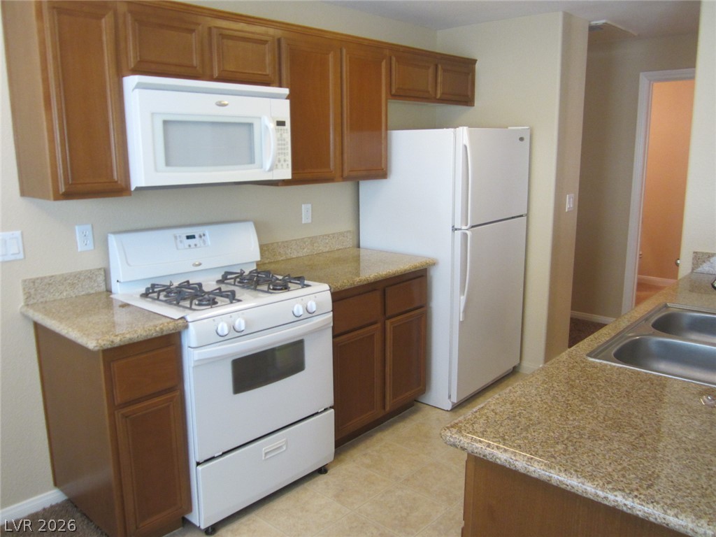 7701 West Robindale Road, Unit 262 Las Vegas, NV 89113 - Photo 11 of 26 A functional kitchen features generous counter space, a gas range, and essential appliances.