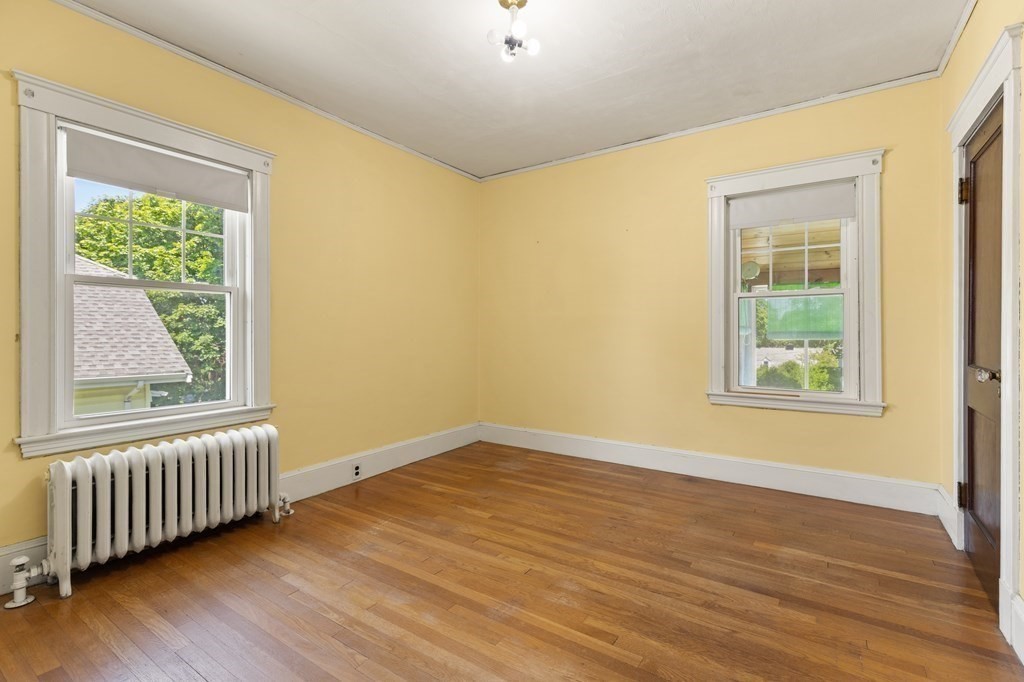 24 Fairbanks Road Milton, MA 02186 - Photo 17 of 19 a view of an empty room with wooden floor and a window