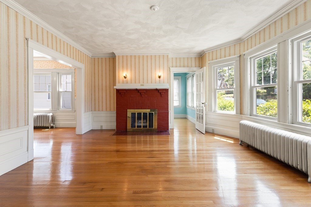 24 Fairbanks Road Milton, MA 02186 - Photo 3 of 19 a view of a livingroom with wooden floor and a fireplace