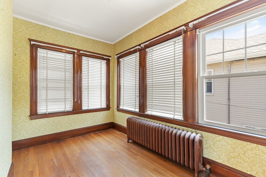 24 Fairbanks Road Milton, MA 02186 - Photo 7 of 19 a view of an empty room with wooden floor and a window