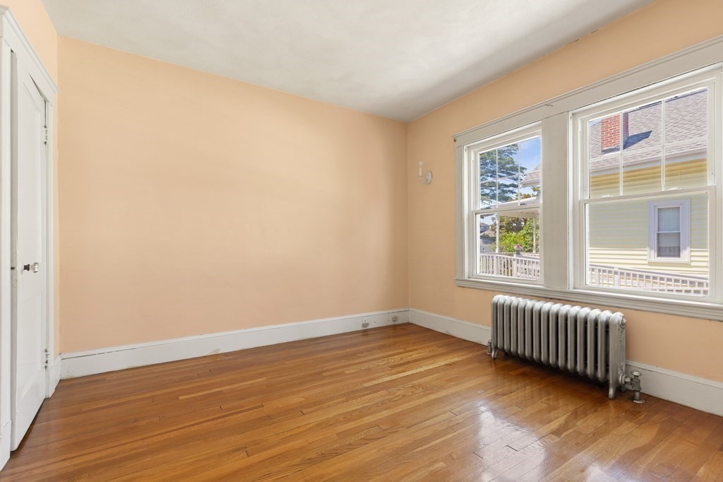 24 Fairbanks Road Milton, MA 02186 - Photo 8 of 19 a view of an empty room with a window and wooden floor