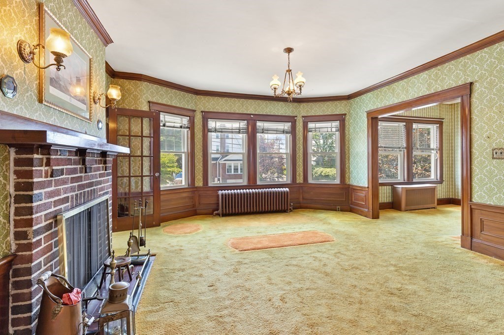 24 Fairbanks Road Milton, MA 02186 - Photo 10 of 19 a view of an empty room with a fireplace and a large window