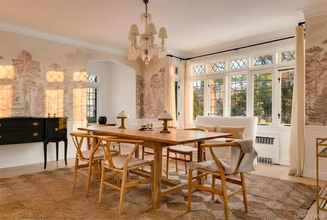 a view of a dining room and livingroom with furniture a chandelier and wooden floor