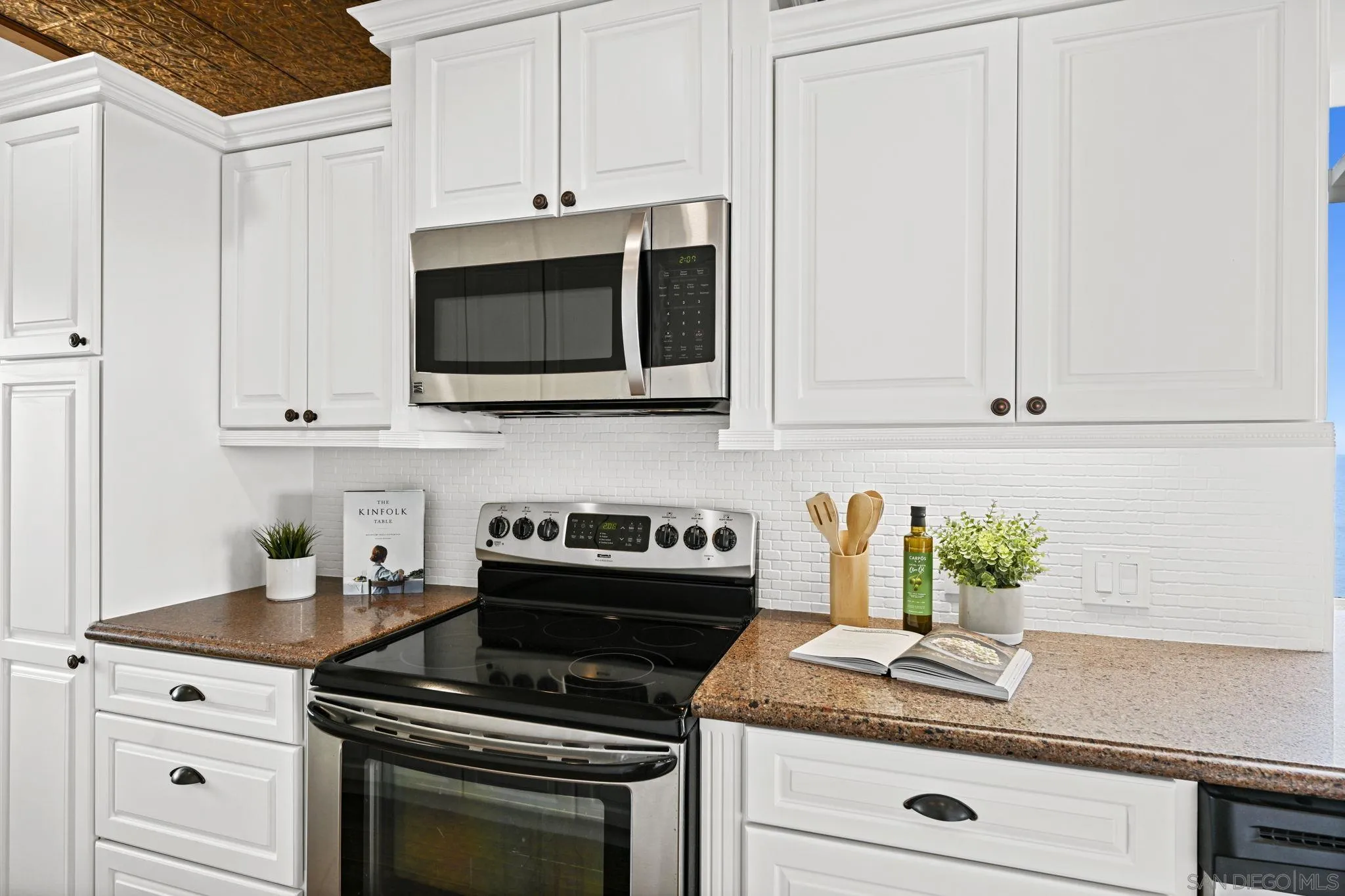 337 West I Street Encinitas, CA 92024 - Photo 20 of 58 a kitchen with granite countertop white cabinets appliances and a counter space