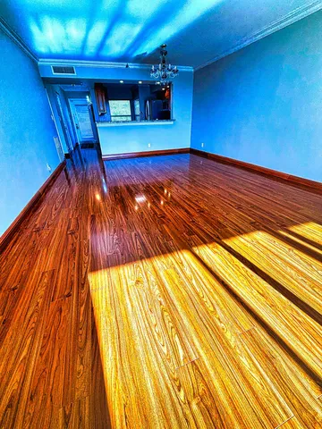 a view of an empty room with wooden floor